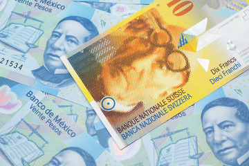 A yellow, ten Swiss franc note from Switzerland close up in macro with Mexican twenty peso bank notes