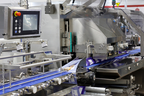 A fragment of the packaging system. Automatic conveyor for food packaging. Conveyor belt at a food factory.