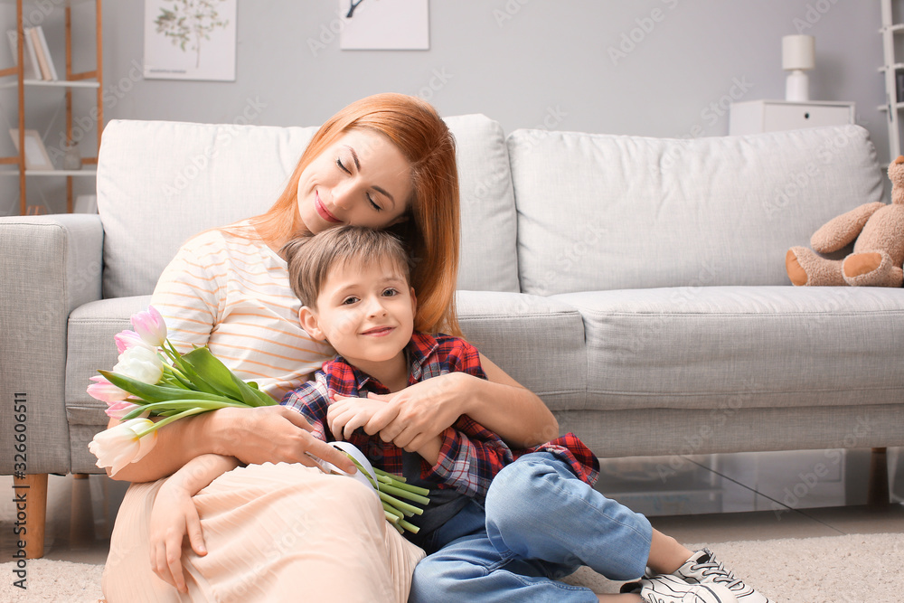 Little boy greeting his mother at home