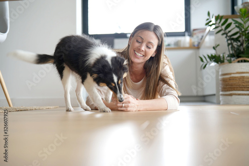 Fotomural Woman at home sittign on floor with puppy dog