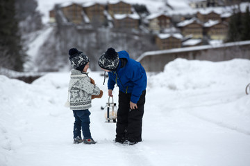 Poster - Cute boy playing with teddy bear in the snow, winter time. Little toddler playing with toys on snowy day