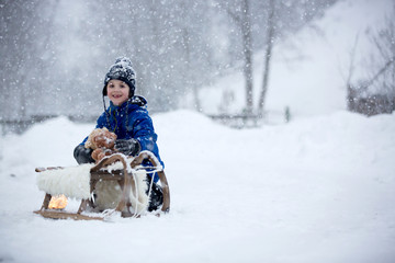 Poster - Cute boy playing with teddy bear in the snow, winter time. Little toddler playing with toys on snowy day