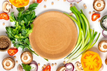 Wall Mural - Fresh vegetables, chickpeas and herbs around blank paper plate on a white background, top view, flat lay. Vegetarian or diet food concept, plastic free, zero waste. Food background.