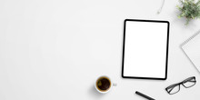 Office Desk With Tablet Mockup And Negative Space. Cup Of Coffee, Plant, Glasses, Pen And Pad Beside. Hero, Header Image Or Banner Composition