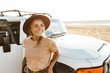 © Drobot Dean - Beautiful young girl standing at the car at the sunny beach