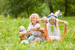 Kinder toben mit ihren Eltern im Gras herum