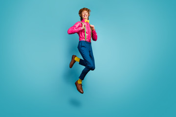 Poster - Full length photo of enthusiastic cheerful guy jump enjoy spring free time holiday jump pull suspenders wear trendy pink shoes isolated over blue color background