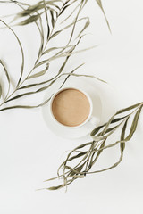 Wall Mural - Closeup of stringy green plant and coffee cup on white background. Flat lay, top view.