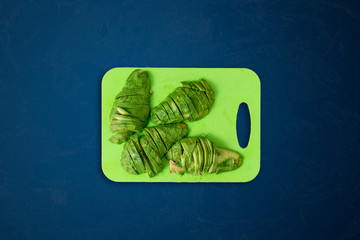 Wall Mural - a small simple cutting board with cut pieces of the fresh avocado for guacamole  on the table surface isolated