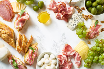 Big plate of appetizers for party of breakfast. Set of gourmet cheese and meat. Overhead view with copy space