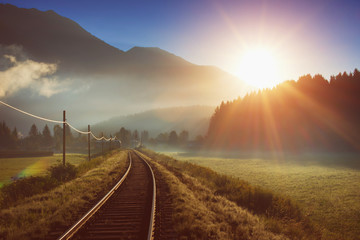 Railway and train in the Alpes at sunrise