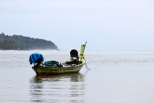 Empty Fishing Boat In The Tropical Sea On Background Of Green Coast And Misty Mountains. Picturesque Seascape In SouthEast Asia