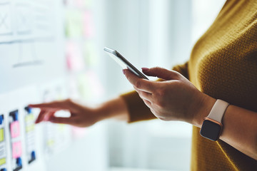Wall Mural - close up of woman with mobile phone planning website on whiteboard
