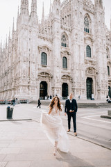 Wall Mural - groom and bride posing in front of the church