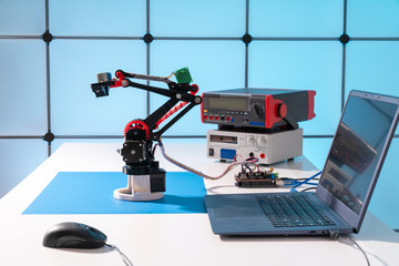 Wall Mural - Model of a robot and a laptop on a table in a design office