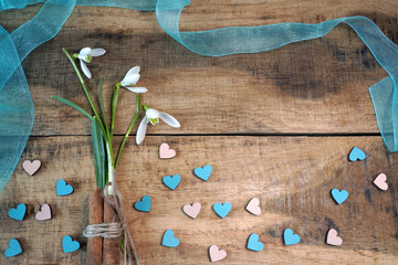 Wall Mural -  Snowdrops and hearts on wooden background