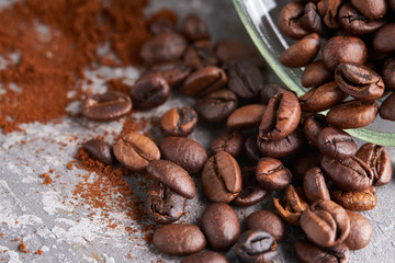 Close up coffee beans in a glass jar on gray stone table