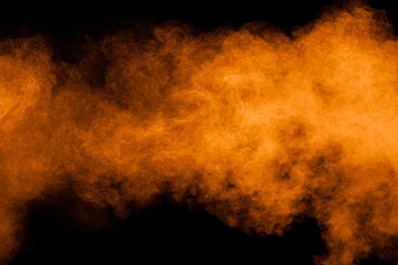 Wall Mural - orange powder explosion on black background. orange color dust splash.