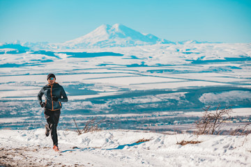 A man goes in for sports against the background of mountains