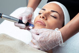 Fototapeta  - Cosmetologist making mesotherapy injection with dermapen on face for rejuvenation on the spa center.