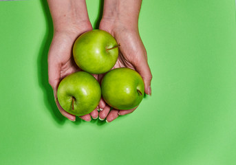 Lemon in hand on green background. Flat lay, top view, copy space . Food dietary concept.