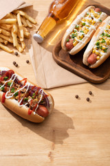 Wall Mural - delicious hot dogs near beer and french fries on wooden table