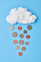 a fluffy white cloud raining coins