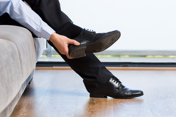 businessman taking off shoes after work at home