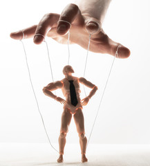 Wall Mural - Concept of control. Marionette in human hand. Image on white.