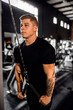 © JonoErasmus - Young man doing cable tricep pulldowns during his gym workout