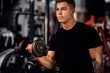 © JonoErasmus - Fit young man weight training with dumbbells in a gym
