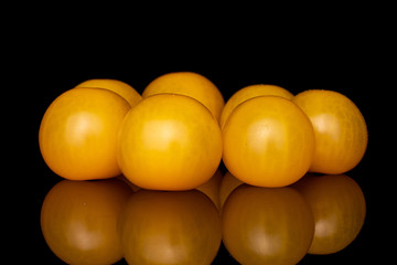 Wall Mural - Group of seven whole fresh yellow tomato isolated on black glass