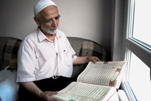 Wise Old Muslim Man Wearing Taqiyah Reads Turkish Translation Of Quran In Passion