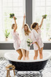 young beautiful blonde wedding bride in a beautiful white dress having fun with bridesmaids in the bathroom