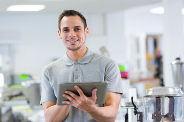 smiling young man using digital tablet in the office