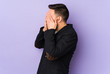 © Asier - Young caucasian man isolated on purple background afraid covering eyes with hands.