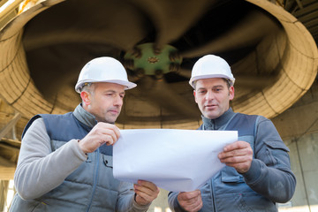 workers discussing paperwork on construction site