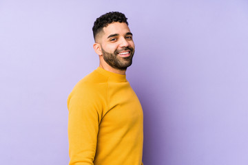 Wall Mural - Young mixed race arabic man isolated looks aside smiling, cheerful and pleasant.