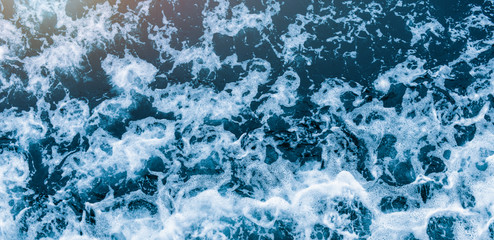 Wall Mural - Background shot of aqua sea water waves surface. Blue ocean water and foam aerial or drone photo.