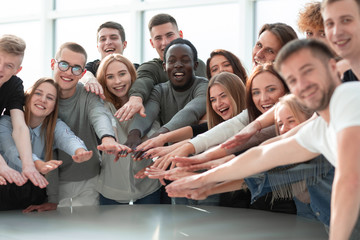 group of smiling young people joining their hands