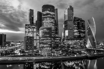 Business district of the city. Night photography of the financial center of Moscow. Skyscrapers shimmering with colorful lights. Reflection in the water of the river.