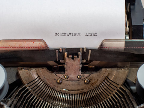 close-up text CORONAVIRUS ALERT. old vintage typewriter with a sheet of white paper