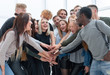 © ASDF - diverse young people putting their hands together