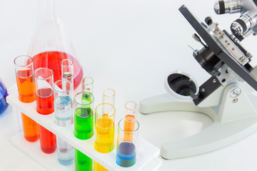 Poster - Test tubes in a stand and a microscope on a white table