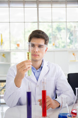 Poster - A male scientist working in a science lab with various equipment in the lab