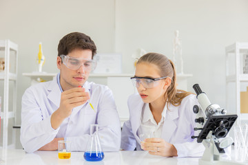 Poster - Male and female scientists working in a science laboratory with various equipment in the laboratory.