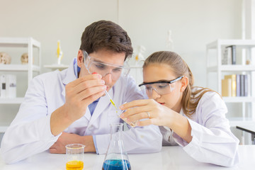 Poster - Male and female scientists working in a science laboratory with various equipment in the laboratory.