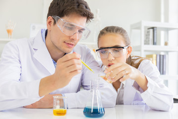 Poster - Male and female scientists working in a science laboratory with various equipment in the laboratory.