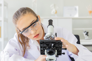 Poster - A beautiful female scientist is operating in a science lab with various equipment in the lab.