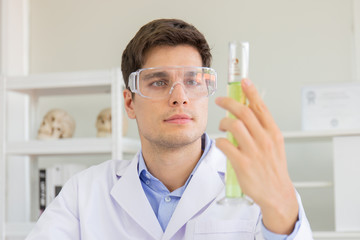 Poster - A male scientist working in a science lab with various equipment in the lab